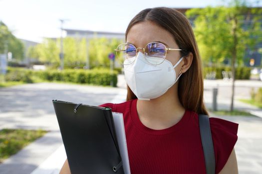 Close up of businesswoman wearing FFP2 KN95 protective mask walking in street
