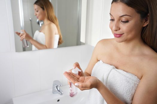 Portrait of girl using cleansing oil to remove makeup. Beauty girl spraying makeup remover cleansing oil in her hand.