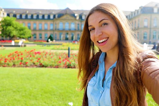 Self portrait of smiling young woman in front of Neues Schloss (New Palace) of Stuttgart, Germany