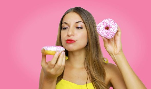Healthy eating, summer, weightloss, healthcare, bodycare lifestyle. Close up portrait of attractive worried doubtful young woman holding yummy white donut hunger and with desire.