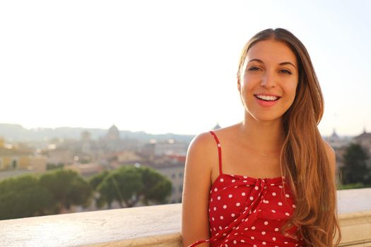 Pretty young woman with cityscape of Rome on the background, Italy.