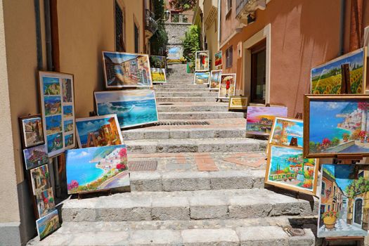 TAORMINA, ITALY - JUNE 20, 2019: cozy flight of steps with paintings in Taormina, Sicily