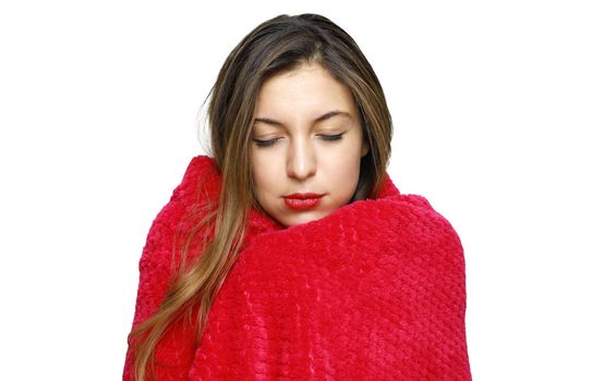Studio shot of young woman wrapped in pink blanket with closed eyes