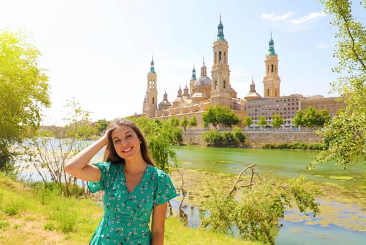 Beautiful attractive young woman with landscape landmark of Zaragoza, Spain.