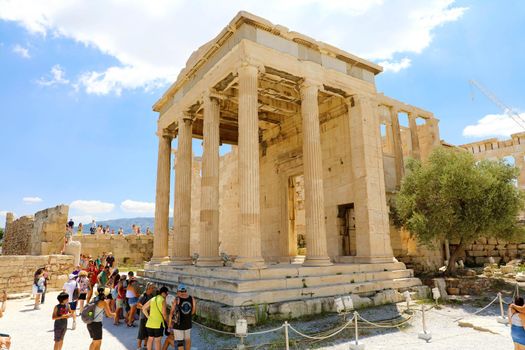 ATHENS, GREECE - JULY 18, 2018: Erechtheum temple ruins on the Acropolis in a summer day with tourists in Athens, Greece.