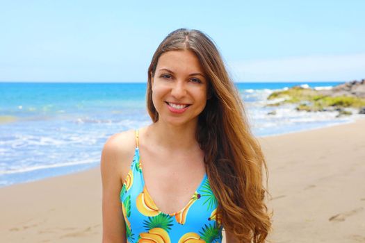 Carefree swimsuit woman enjoying  beach. Beautiful relaxing model with long hair on summer travel vacation in light blue swimsuit in tropical destination.
