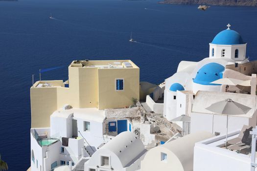 Stunning panoramic view of Santorini island with white houses and blue domes in Oia village, Greece, Europe. Traveling concept background. 
