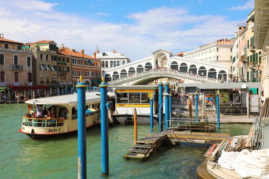 VENICE, ITALY - JUNE 18, 2018: Rialto Bridge over Grand Canal in Venice with traghetto ferry stopped, italy