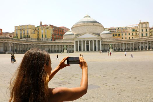 Young woman taking picture of Piazza del Plebiscito square, Naples, Italy