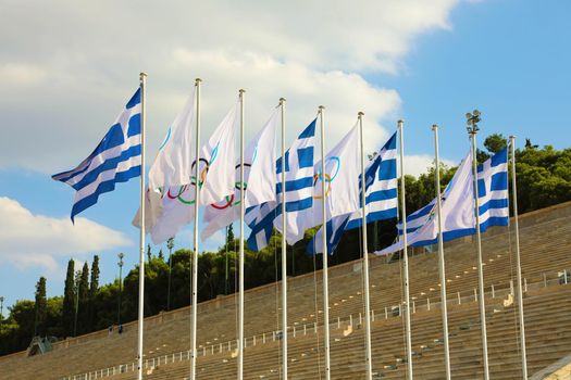 Flags of Greece and flags of Olympic games wave outside of Panathenaic Stadium in Athens, Greece on July 18, 2018