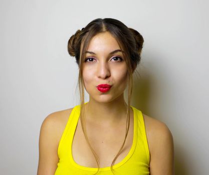 Beautiful girl with two hair chignon send kiss to the camera
