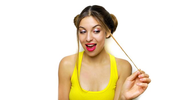 Happy funny girl with hair chignon playing with her hair while s