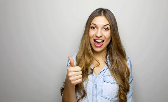 Young happy cheerful woman showing thumb up