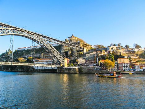 Porto / Portugal - November 27 2010: Panorama of the city, metallic Dom Luis bridge over Douro river and tourist Rabelo Boat