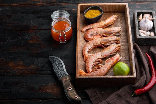 Large raw shell on raw king prawns, in wooden box, on old dark wooden table background , with copyspace and space for text