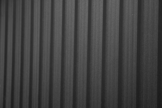 Black corrugated iron sheet used as a facade of a warehouse or factory. Texture of a seamless corrugated zinc sheet metal aluminum facade. Architecture. Metal texture
