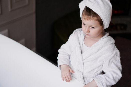Little girl in a white robe after taking a bath.