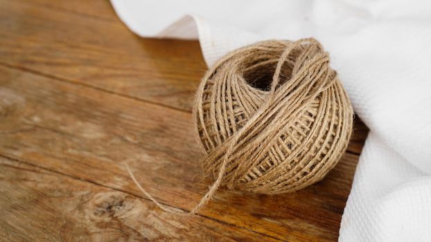 Skeins of jute rope on wooden table flat lay background with copy space.