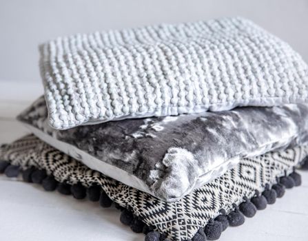 Close up of stylish textured pillows stacked in a stack.