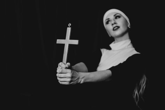 Nun holding a cross. The concept of religion.