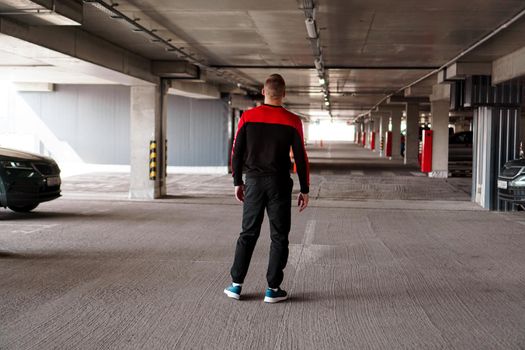 A young man in a sports uniform in an underground parking lot.