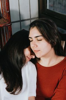 Lesbian couple resting on each other with the eyes closed relaxing