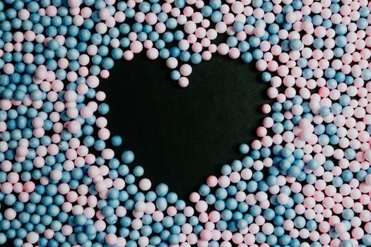 A black heart in the middle of pink and blue balloons love and equality concepts background