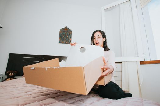 Young arab woman opening a box with products, concept retail and buying online