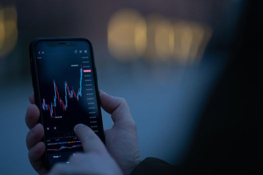 Trader checking stock market data on smartphone