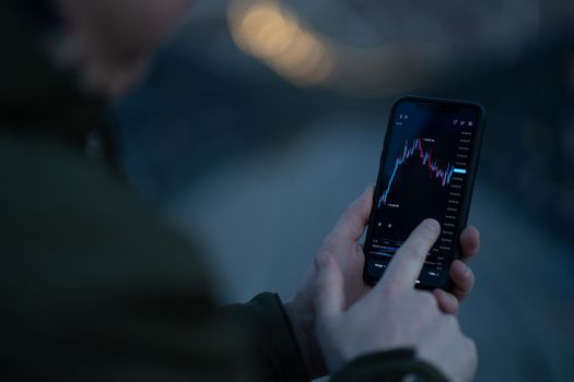 Businessman monitoring stock market data while trading online in mobile app