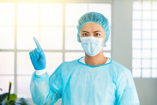 asian male doctor in medical mask and  pointing upper left corner