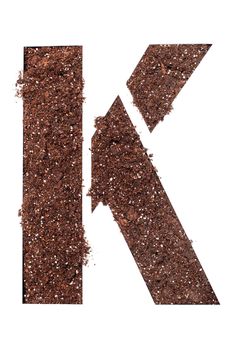 stencil letter K made above dirt on white surface