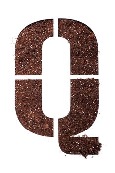 stencil letter Q made above dirt on white surface