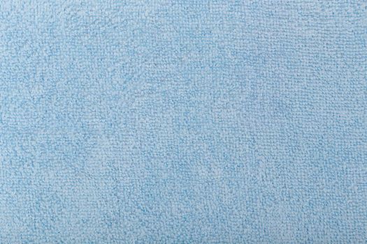 Blue fleecy fabric background. Top view of bright blue fiber.