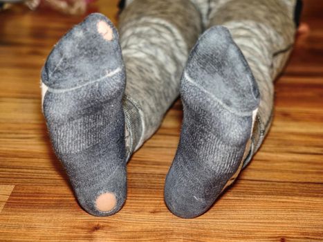 Kid wearing sweaty socks with holes in heel