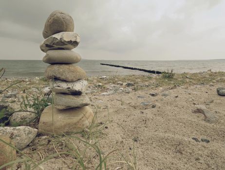 Pyramid of sea stones on pebbles of the sea shore. Seascape. 