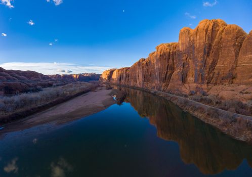 Colorado River and Red Sandstone Cliffs on Sunny Day. Wall Street Rock Climbing Area. Blue Sky Reflection in Water. Grand County, Utah, USA. Aerial View