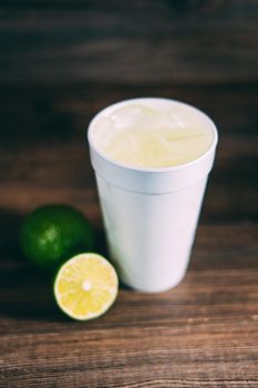 A styrofoam cup and a citrus fruit
