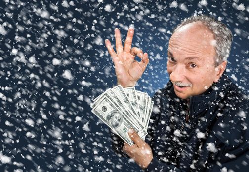 man with a bundle of dollars in snowfall
