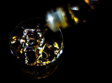 pouring single malt whisky into a glass, golden color whisky