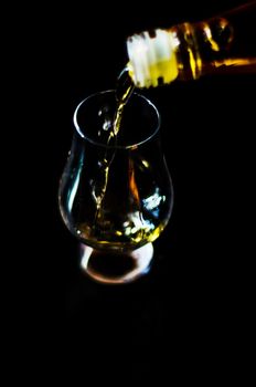 pouring single malt whisky into a glass, golden color whisky