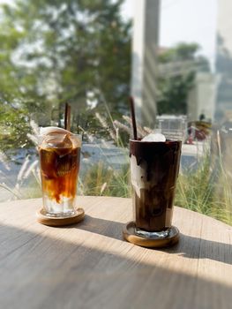 A glass of iced mocha and iced americano with coconut juice