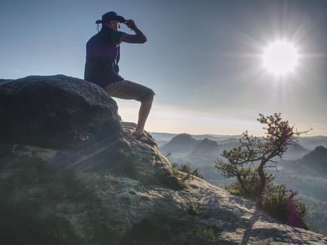 Trekker in cowboy hat on mountain with Sunrise enjoy view