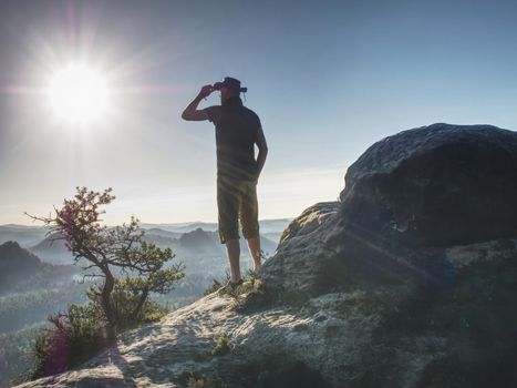 Trekker in cowboy hat on mountain with Sunrise enjoy view