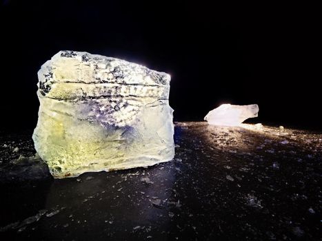 Ice floe and crushed ice on dark frozen and flat  ground. Shining crushed ice