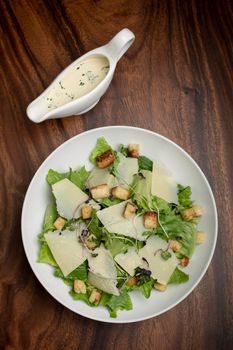 caesar salad with parmesan cheese and croutons on table