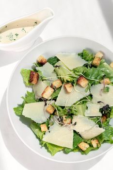 caesar salad with parmesan cheese and croutons on table