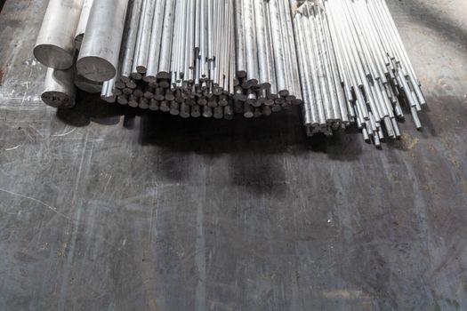 aluminium round long products on black steel surface