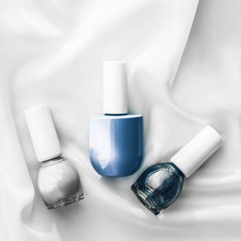 Nail polish bottles on silk background, french manicure products and nailpolish make-up cosmetics for luxury beauty brand and holiday flatlay art design