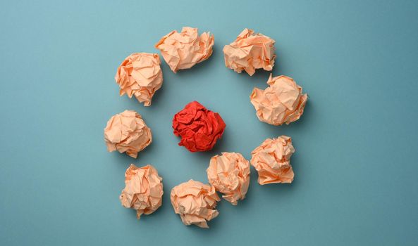 crumpled balls of paper on a blue background, top view. The concept of finding innovative ideas